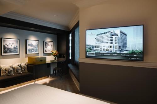 a bedroom with a large flat screen tv on a wall at Grand Park City Hall in Singapore