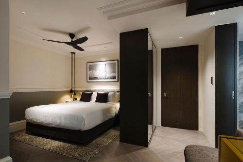 a bedroom with a bed with a ceiling fan at Grand Park City Hall in Singapore
