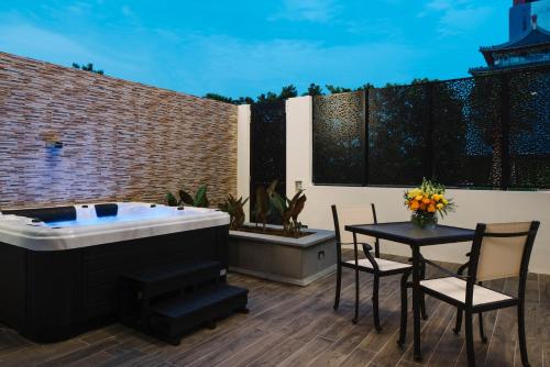 a hot tub on a patio with a table and chairs at Grand Park City Hall in Singapore