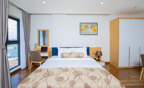 - une chambre avec un grand lit et un bureau dans l'établissement HSuites Hotel and Apartment, à Đà Nẵng