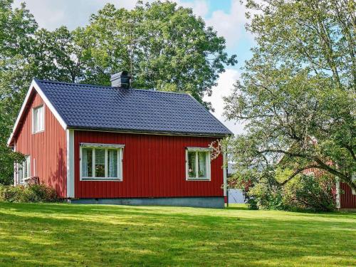a red house with a black roof on a green field at 6 person holiday home in ED in Ed