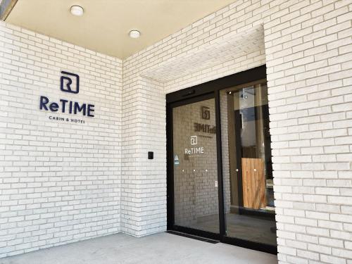 a white brick wall with a entrance to a store at CABIN&HOTEL ReTIME in Naha