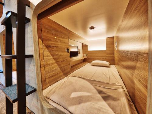 a small room with a bed inside of it at CABIN&HOTEL ReTIME in Naha