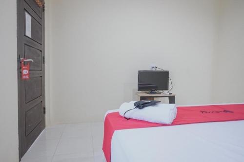 a bedroom with a bed and a television on a table at RedDoorz Syariah near Kantor Walikota Jambi in Jambi