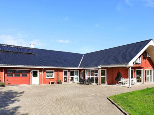 ein rotes Gebäude mit einer Solaranlage darauf in der Unterkunft 9 person holiday home in S by in Sæby