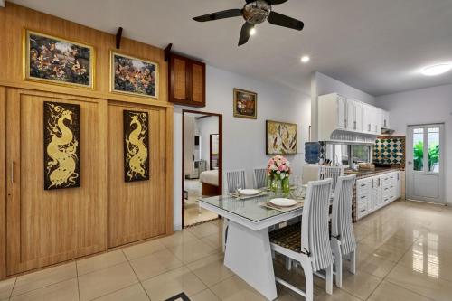 a kitchen and dining room with a table and chairs at Siam Gala Villa in Pattaya South