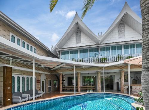 an exterior view of a house with a swimming pool at Siam Gala Villa in Pattaya South