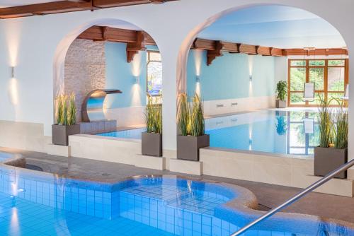 una gran piscina con suelo de baldosa azul y una piscina en Hotel Celler Tor, en Celle