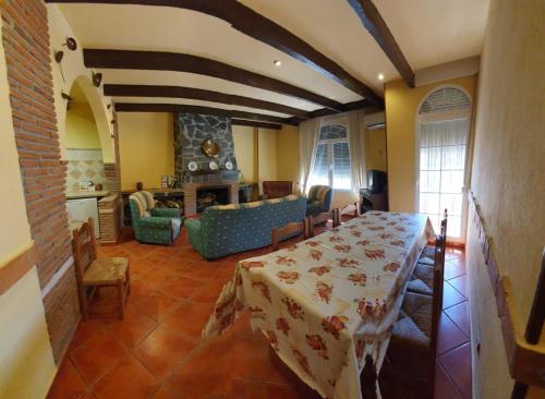 a dining room with a table and a living room at Monte Rosado viviendas vacacionales in Lapeza