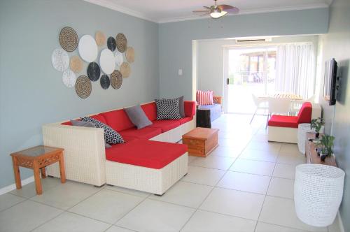 uma sala de estar com um sofá vermelho e piso em azulejo branco em 28 and 29 The Bridge em St. Lucia