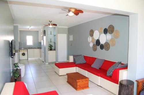 a living room with a red couch and a kitchen at 28 and 29 The Bridge in St Lucia