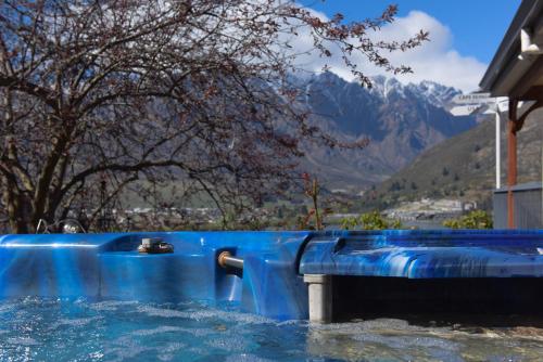 a water slide in a pool with mountains in the background at The Embassy B&B in Queenstown