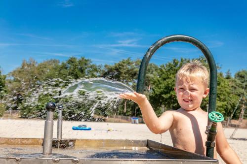 a young boy playing in a water fountain at Vakantiepark de Bergen in Wanroij