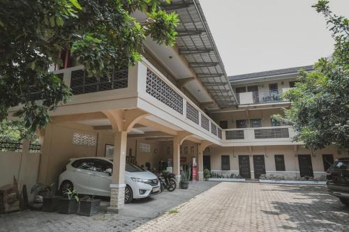a white car parked in front of a building at RedDoorz Syariah near Jamtos Jambi 2 in Jambi