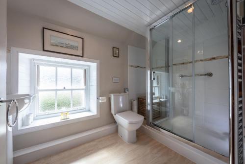 un bagno con wc e doccia in vetro di Beachcomber Cottage a Stein