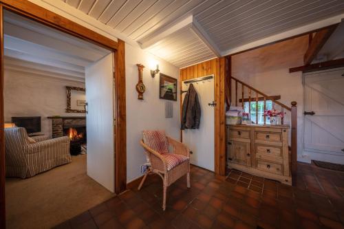 un soggiorno con sedia, tavolo e camino di Beachcomber Cottage a Stein