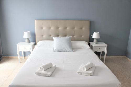 カジャオ・サルバヘにあるApartamento I Callao Salvajeの白い大型ベッド(白いタオル2枚付)