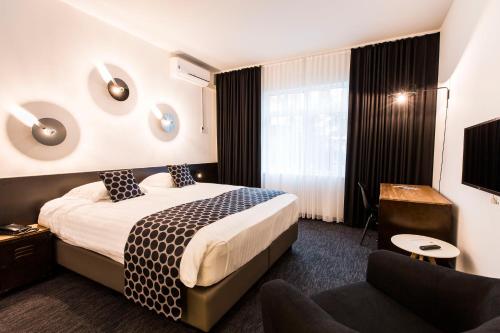 a hotel room with a bed and a couch at Let's Meet Elewijt in Elewijt