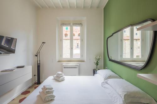 a bedroom with a mirror and a bed with towels at Bellavalle ROOMS Vinci Florence Tuscany in Vinci