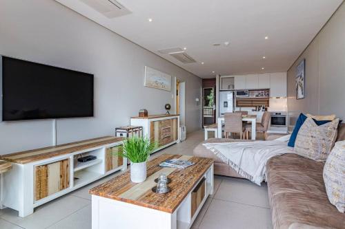 a living room with a couch and a flat screen tv at Suite 501, Zimbali Suites in Ballito
