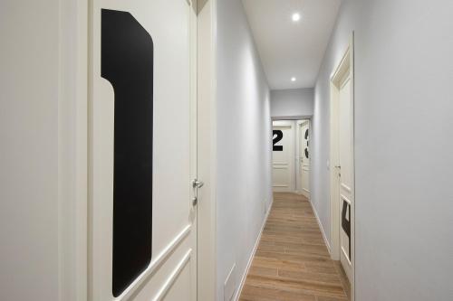 a hallway with white walls and a black and white door at Affittacamere I Canneggiatori in Abbadia San Salvatore