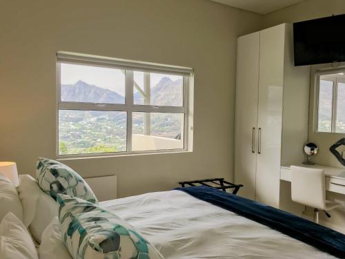 a bedroom with a bed and a window at Mount Bay in Hout Bay