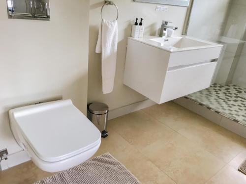 a bathroom with a white toilet and a sink at Mount Bay in Hout Bay
