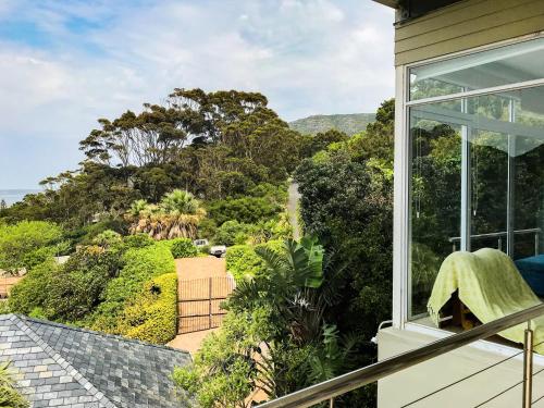 a room with a balcony with a view of trees at Mount Bay in Hout Bay
