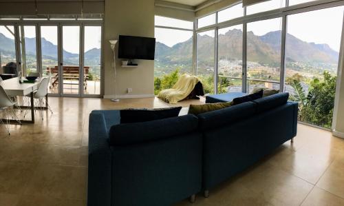 a living room with a blue couch and a view of mountains at Mount Bay in Hout Bay