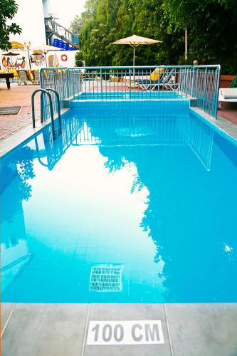 a large blue swimming pool with an umbrella at Hotel Chateau de Ville in Marmaris