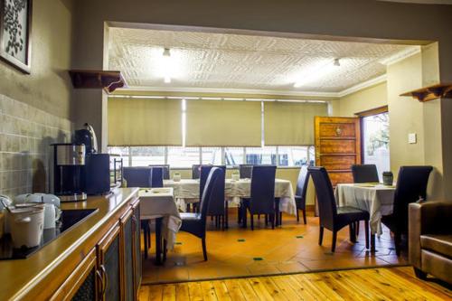 a restaurant with a dining room with tables and chairs at Nobis House in Bloemfontein