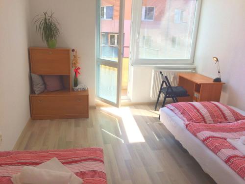 sypialnia z łóżkiem, biurkiem i oknem w obiekcie City Centre Apartment Liptovsky Mikulas w Liptowskim Mikulaszu