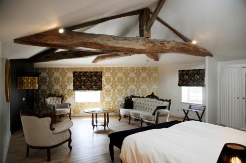 a bedroom with a bed and furniture in a room at Frédéric Carrion - Cuisine, Hôtel & Spa in Viré