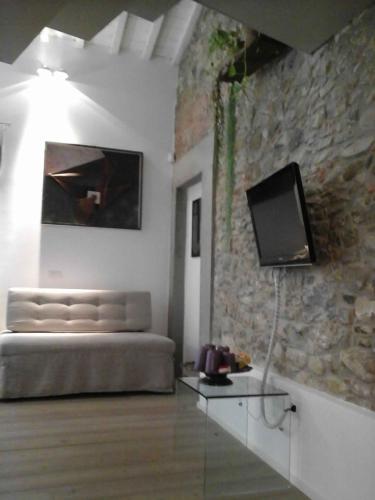 a bedroom with a bed and a tv on a stone wall at Villa Aruch in Florence