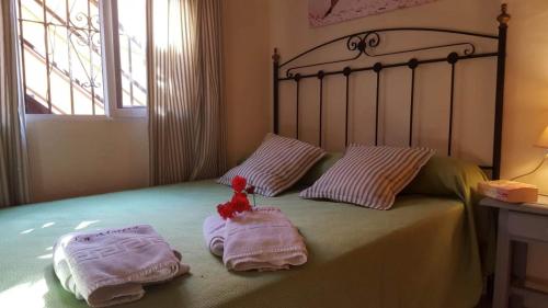 Una cama con dos toallas y un animal de peluche. en La Morera, El Palmar, en El Palmar
