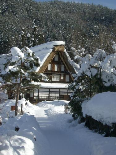 a log cabin in the snow with a tree at BEYOND HOTEL Takayama 1st in Takayama