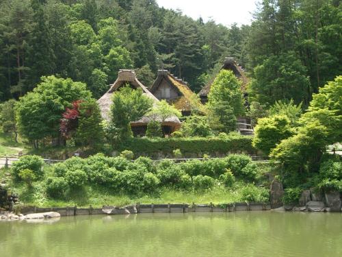 a house sitting on the side of a lake at BEYOND HOTEL Takayama 1st in Takayama