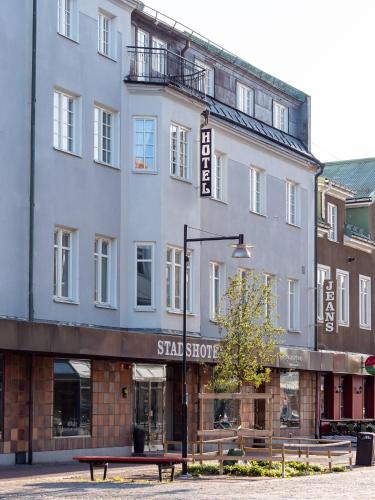 a large white building with a bench in front of it at Ludvika Stadshotell in Ludvika