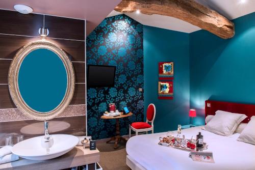 a room with a bed and a sink and a mirror at Frédéric Carrion - Cuisine, Hôtel & Spa in Viré