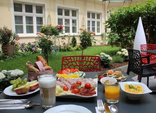 a table with a plate of food and drinks at Hotel Josefshof am Rathaus in Vienna