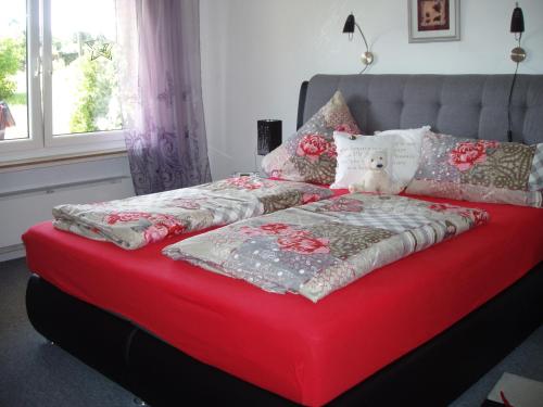 ブラウンラーゲにあるHerzlich & Harzlich Willkommenのベッド(赤い毛布、枕付)
