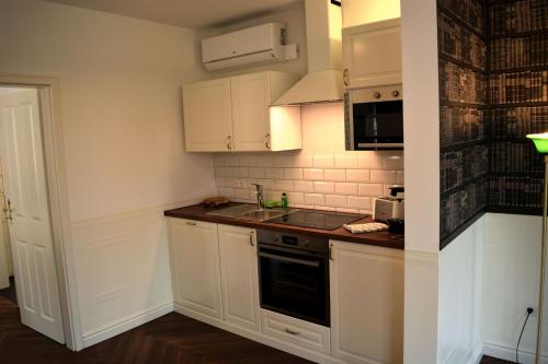 a small kitchen with white cabinets and a sink at ROSER Suiten in Gengenbach