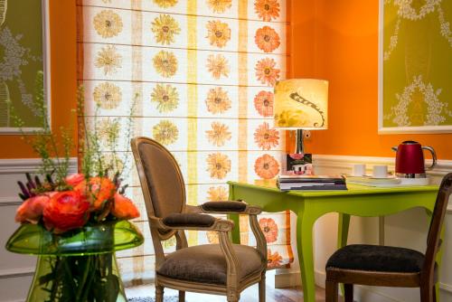 an orange room with a green desk and chairs at Frédéric Carrion - Cuisine, Hôtel & Spa in Viré