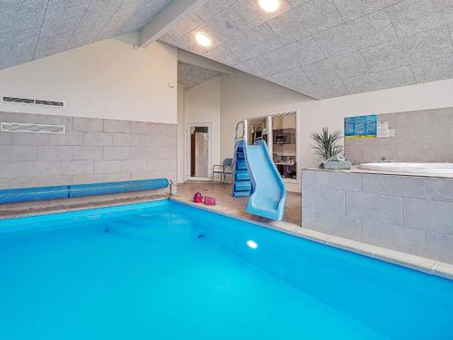 a large swimming pool with a slide in a room at 18 person holiday home in Grenaa in Grenå