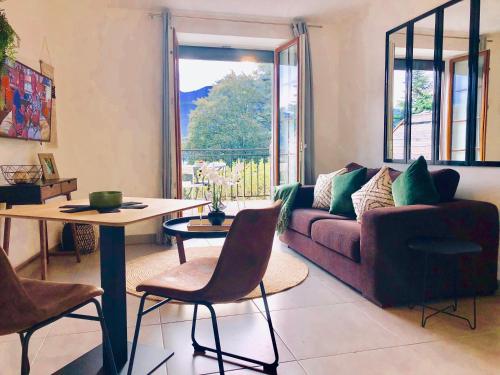 un salon avec un canapé et une table dans l'établissement Appartement T2, vue lac, climatisé, parking, tout confort, à Aix-les-Bains