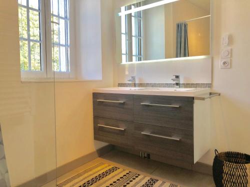 une salle de bain avec un lavabo et un miroir dans l'établissement Appartement T2, vue lac, climatisé, parking, tout confort, à Aix-les-Bains
