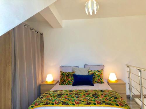 - une chambre avec un lit et deux lampes de chaque côté dans l'établissement Appartement T2, vue lac, climatisé, parking, tout confort, à Aix-les-Bains