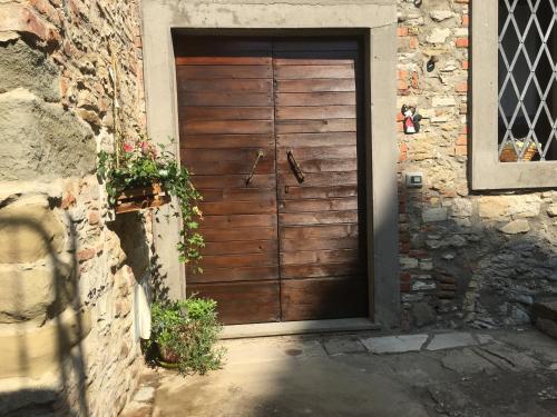 uma porta de madeira num edifício com uma parede de pedra em CASA AZZURRA MONTE SANTA MARIA TIBERINA em Monte Santa Maria Tiberina