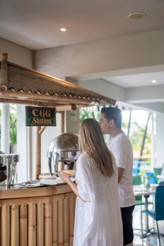 a man and a woman standing at a counter at EDEN Hotel Kuta Bali in Kuta