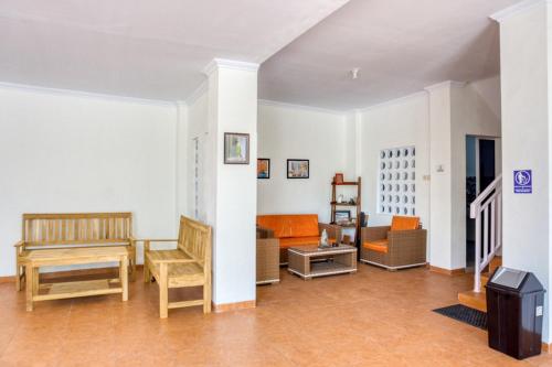 a living room with chairs and a piano at RedDoorz Syariah near Taman Pelangi Monjali in Yogyakarta